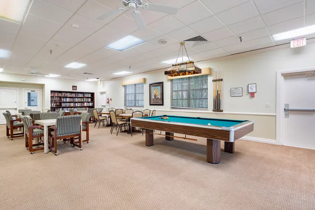 a room with pool table and windows