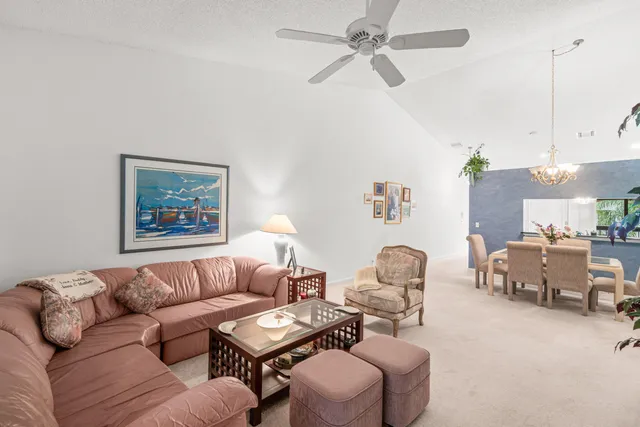 a view of a dining room with furniture a chandelier and wooden floor