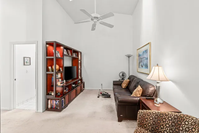 a living room with furniture a bookshelf and a window