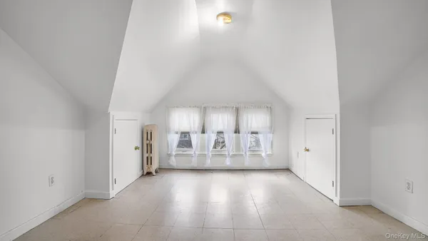 an empty room with windows and fireplace