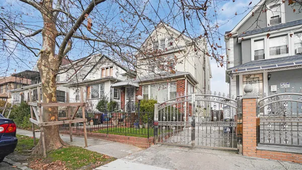 a view of a brick house with large windows and a large tree