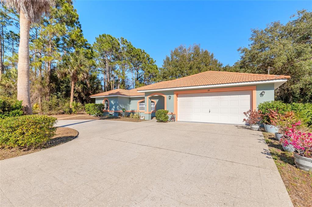 39 Princess Ruth Lane Palm Coast, FL 32164 - Photo 2 of 48 a front view of a house with a yard and a garage