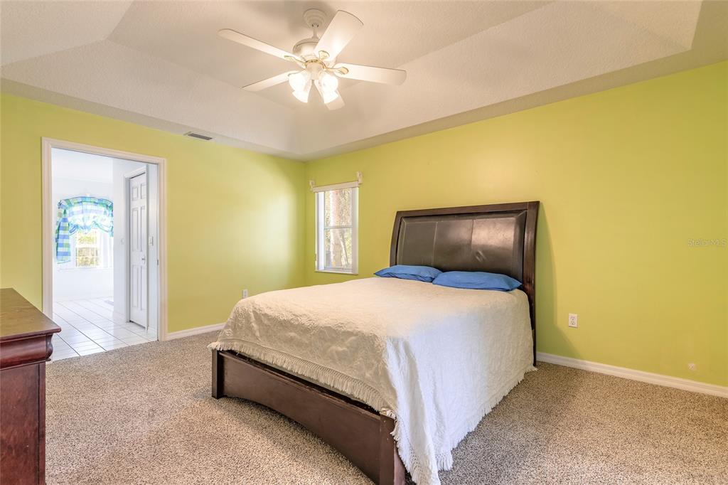 39 Princess Ruth Lane Palm Coast, FL 32164 - Photo 23 of 48 a bedroom with a bed and a chandelier