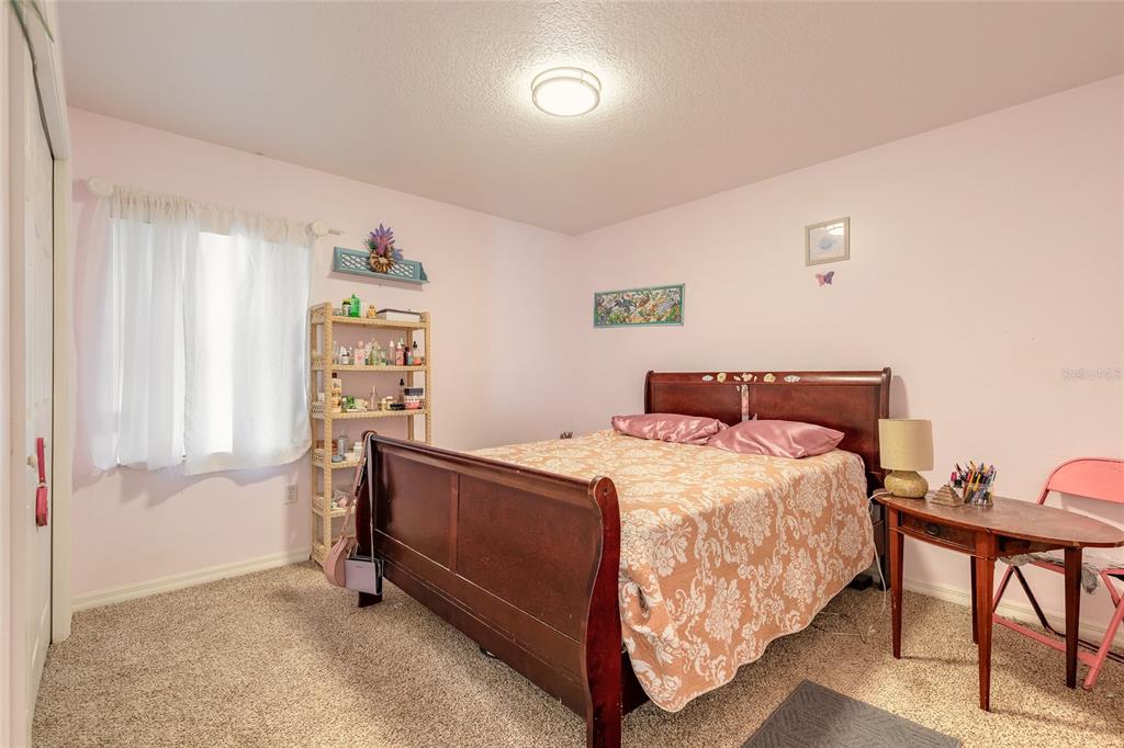 39 Princess Ruth Lane Palm Coast, FL 32164 - Photo 29 of 48 a bedroom with a bed and a table in it