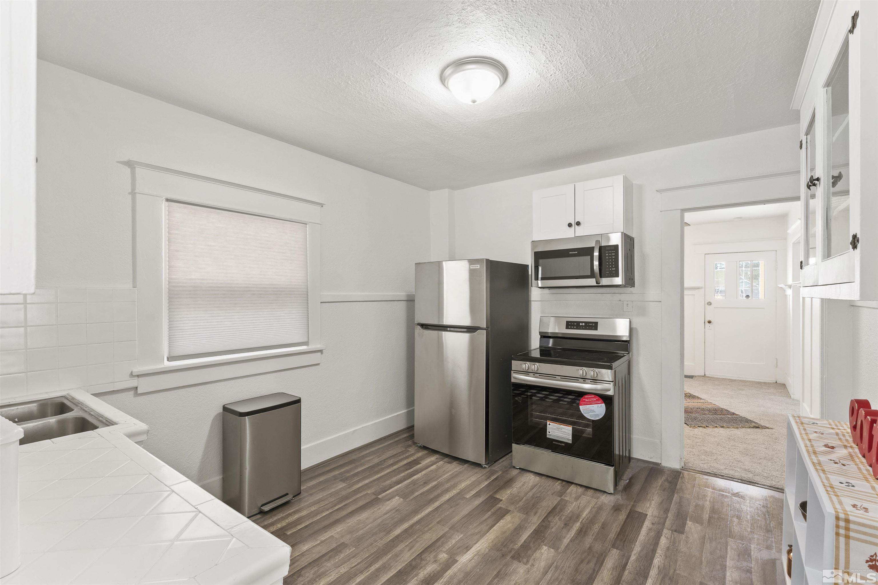 64 Keystone Avenue, Unit 6466 KEYSTONE AVENUE Reno, NV 89503 - Photo 11 of 36 a kitchen with stainless steel appliances a refrigerator and a stove top oven