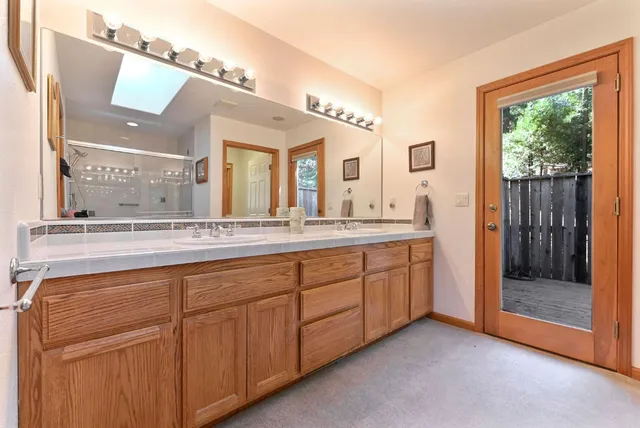 a spacious bathroom with a granite countertop sink mirror and shower