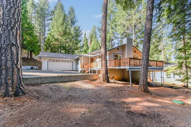 a view of a house with backyard and trees