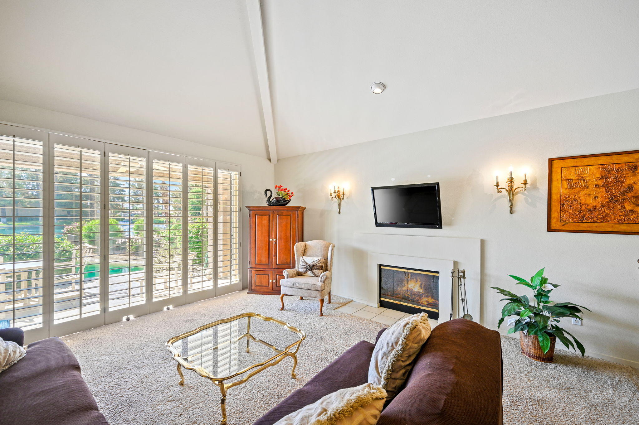 151 Lakeshore Drive Rancho Mirage, CA 92270 - Photo 8 of 37 a living room with furniture a flat screen tv and a fireplace