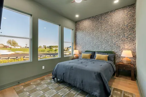 a bathroom with a granite countertop sink a toilet a mirror and shower