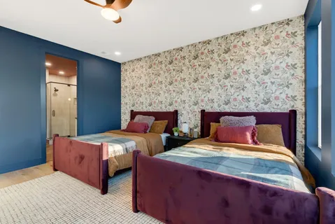 a bedroom with two beds and a flat screen tv