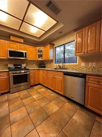 a kitchen with stainless steel appliances granite countertop a stove sink and cabinets