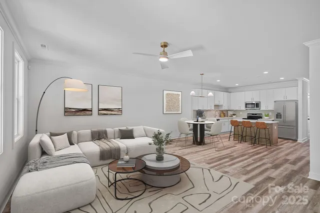 a living room with furniture a rug and kitchen view