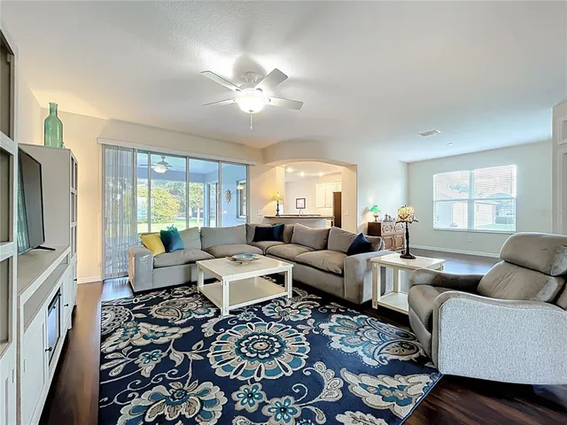 a view of living room with kitchen island stainless steel appliances wooden floor and living room view