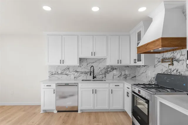 a kitchen with white cabinets and white appliances