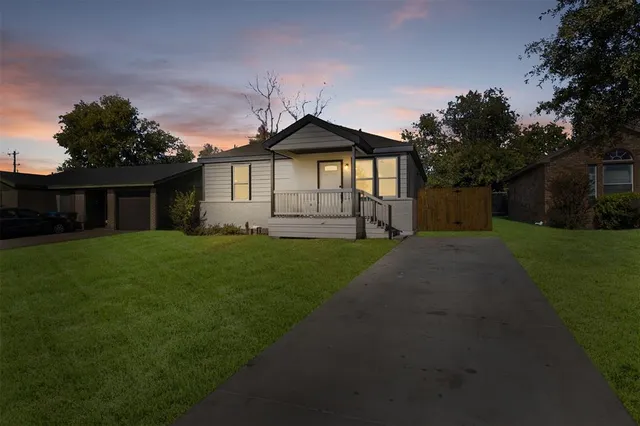 a front view of a house with a yard and trees