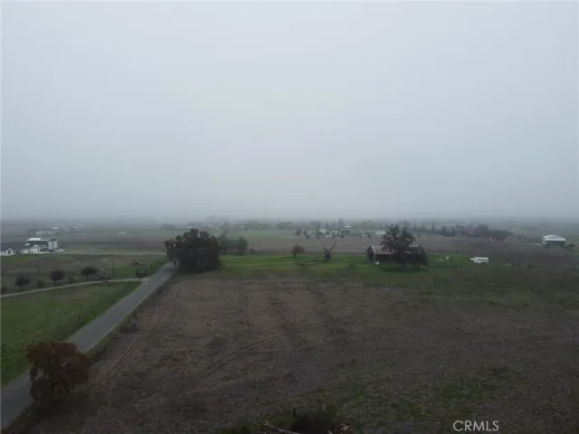 a view of a field with trees in background