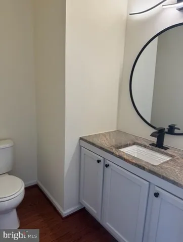 a bathroom with a granite countertop toilet and a sink
