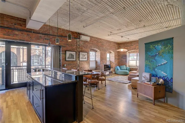 a very nice looking living room with a large dining table and a large window with wooden floor