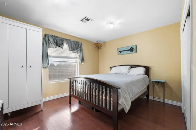 a bedroom with a bed and wooden floor