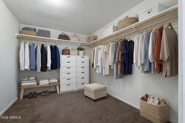 a view of walk in closet with clothes and shoes