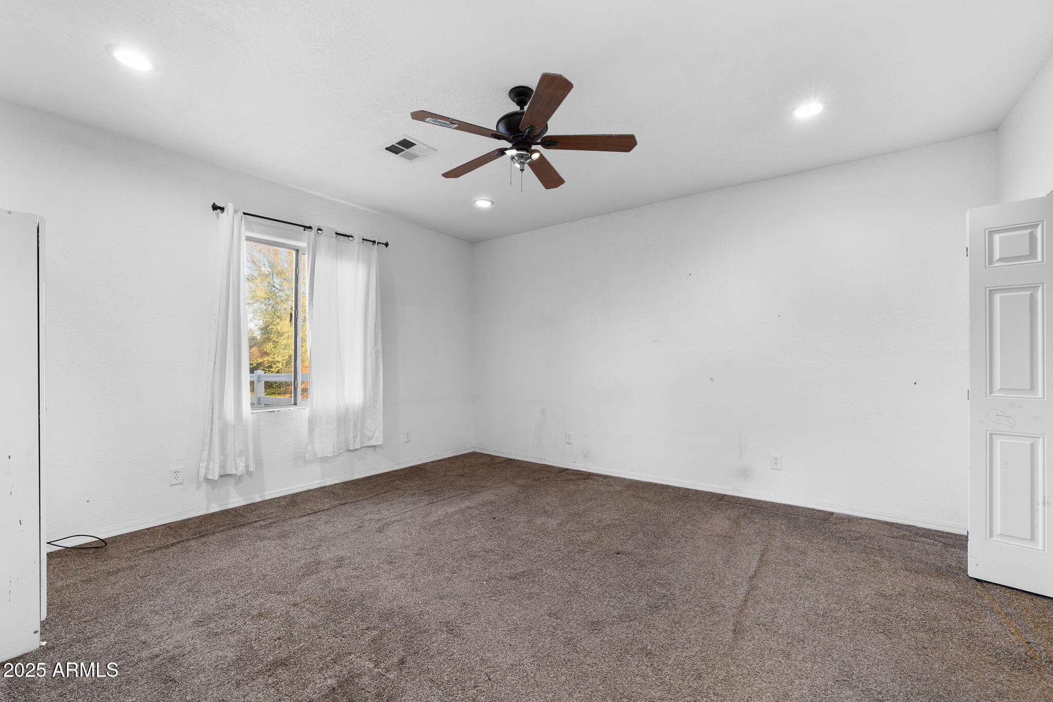 117 North Arroya Road Apache Junction, AZ 85119 - Photo 22 of 27 an empty room with ceiling fan and windows
