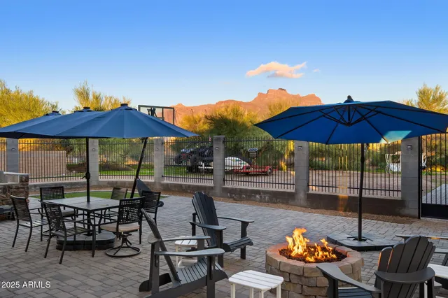 a view of a patio with chairs and table under an umbrella with the umbrella