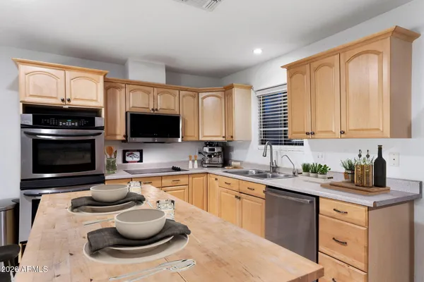 a kitchen with a sink and a stove top oven with wooden floor