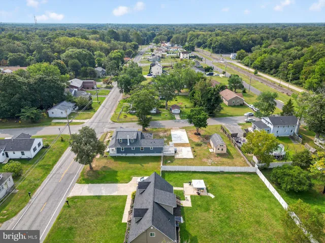 an aerial view of a house with swimming pool a yard and lake view