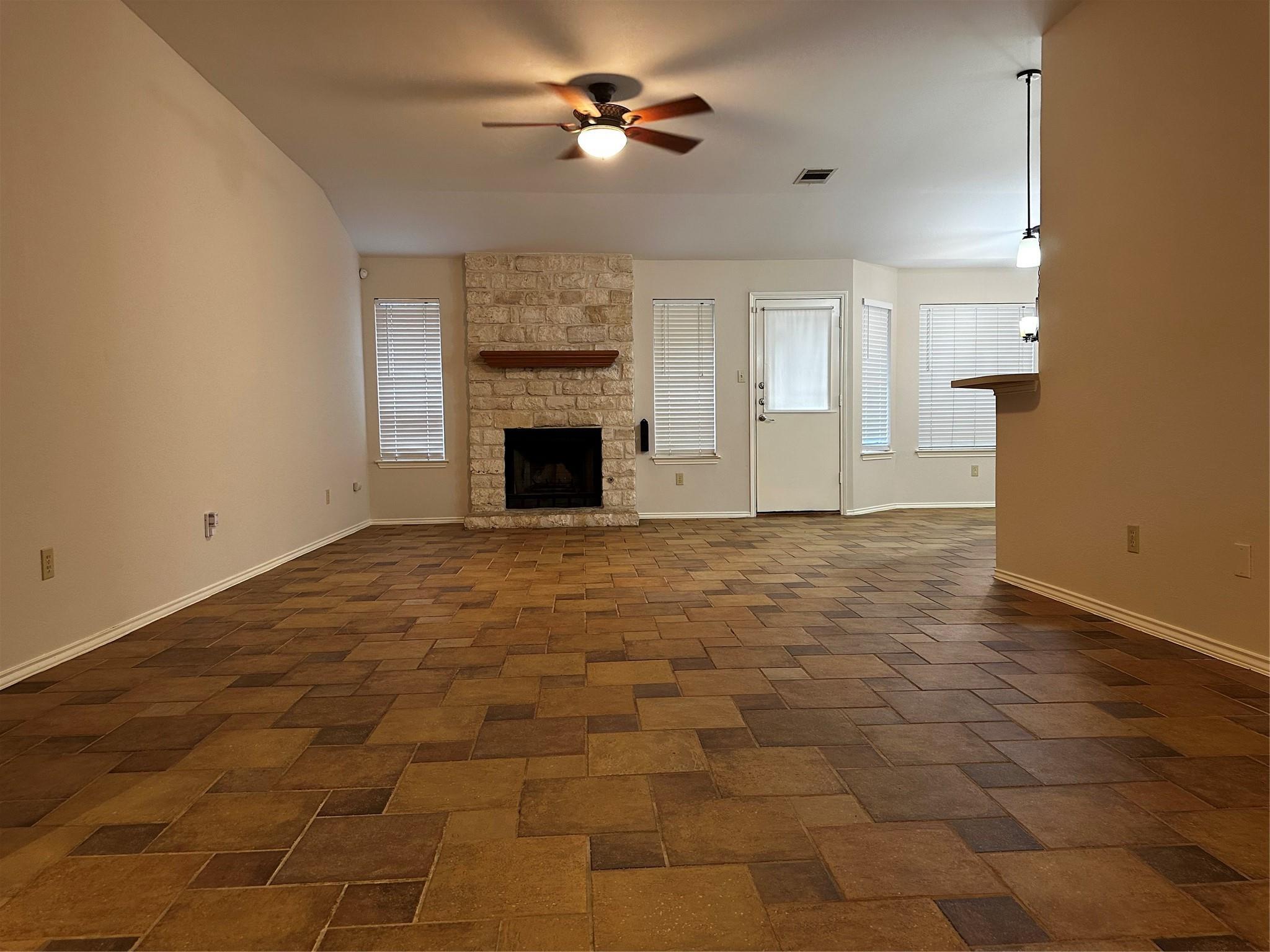 8007 Bounty Trail Austin, TX 78749 - Photo 4 of 32 A spacious common area boasts tiled flooring and a prominent stone fireplace.