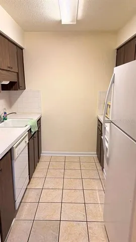 a kitchen with a sink a stove top oven and cabinets