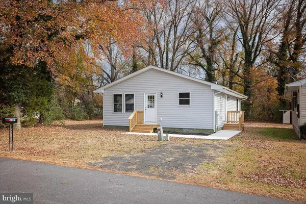 a backyard of a house with wooden fence and large trees