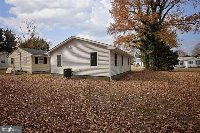 a view of a white house with a yard and large tree