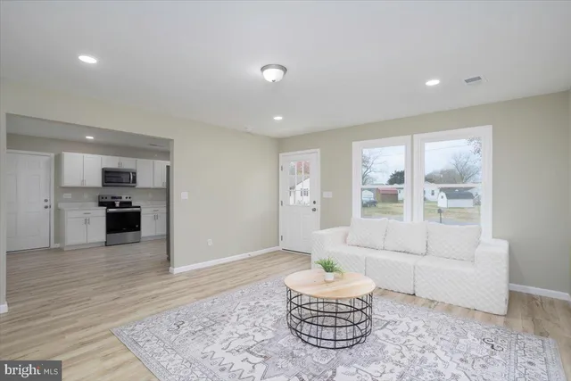 a living room with furniture and a kitchen