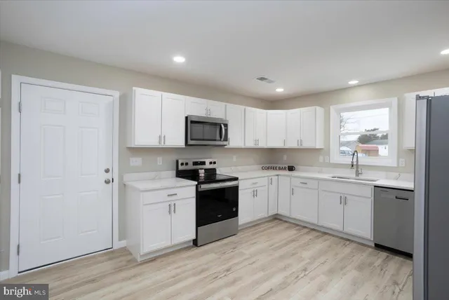 a kitchen with granite countertop white cabinets and white appliances