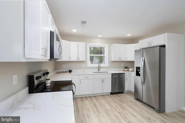 a kitchen with stainless steel appliances granite countertop a refrigerator sink and cabinets
