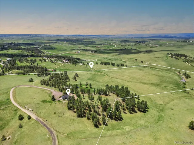 view of house with yard and trees in the background