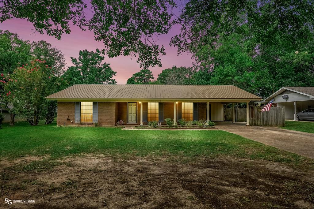 a view of a big house with a big yard and large trees