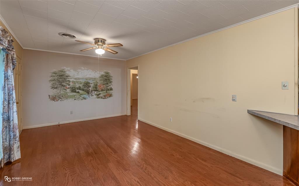 407 Fincher Road Minden, LA 71055 - Photo 6 of 28 an empty room with wooden floor ceiling fan and window