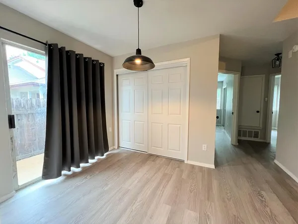 a view of a hallway with wooden floor and a ceiling fan