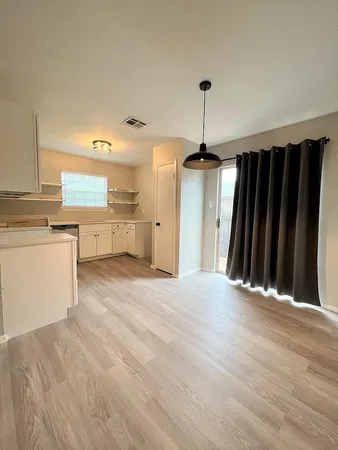 a view of a kitchen with wooden floor and cabinets