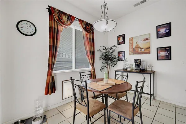a kitchen with a table chairs refrigerator and cabinets