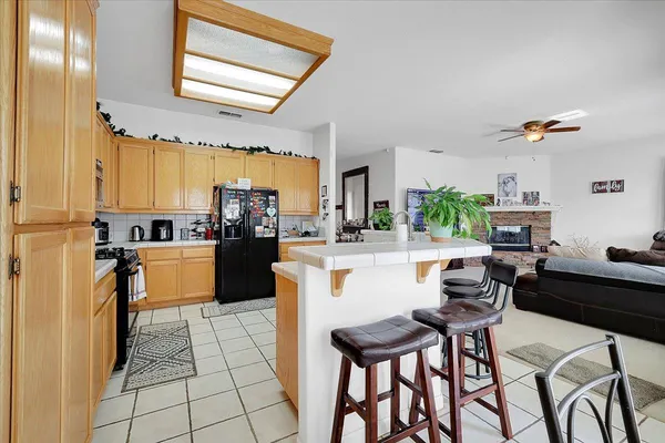 a kitchen with stainless steel appliances granite countertop a stove a sink dishwasher and a microwave oven with cabinets