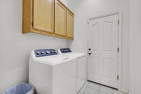 a view of a patio with a table and chairs and a barbeque