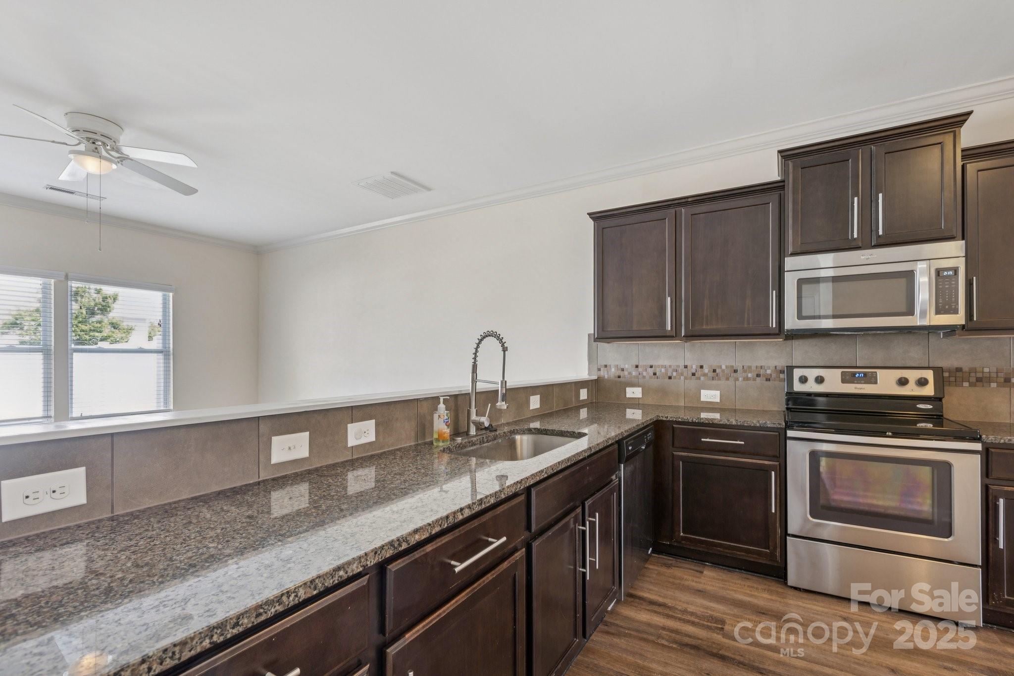 2822 Hopeton Court Monroe, NC 28110 - Photo 7 of 28 a kitchen with stainless steel appliances granite countertop a sink stove and microwave