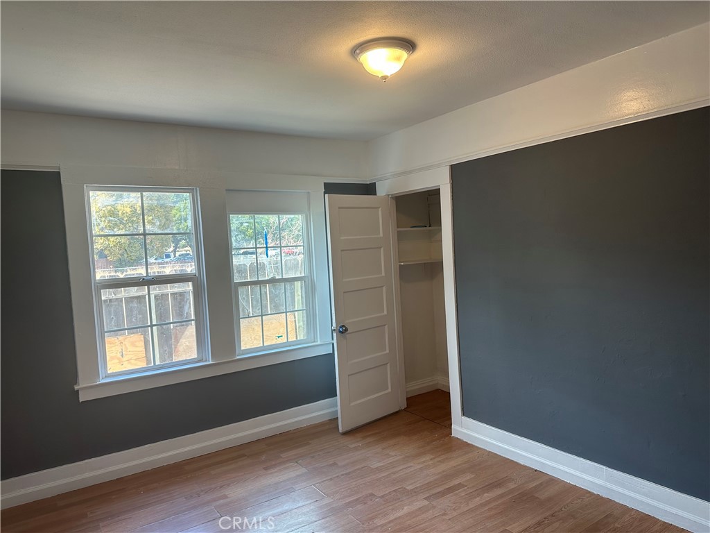 4 West 13th Street Merced, CA 95341 - Photo 11 of 23 an empty room with wooden floor and windows