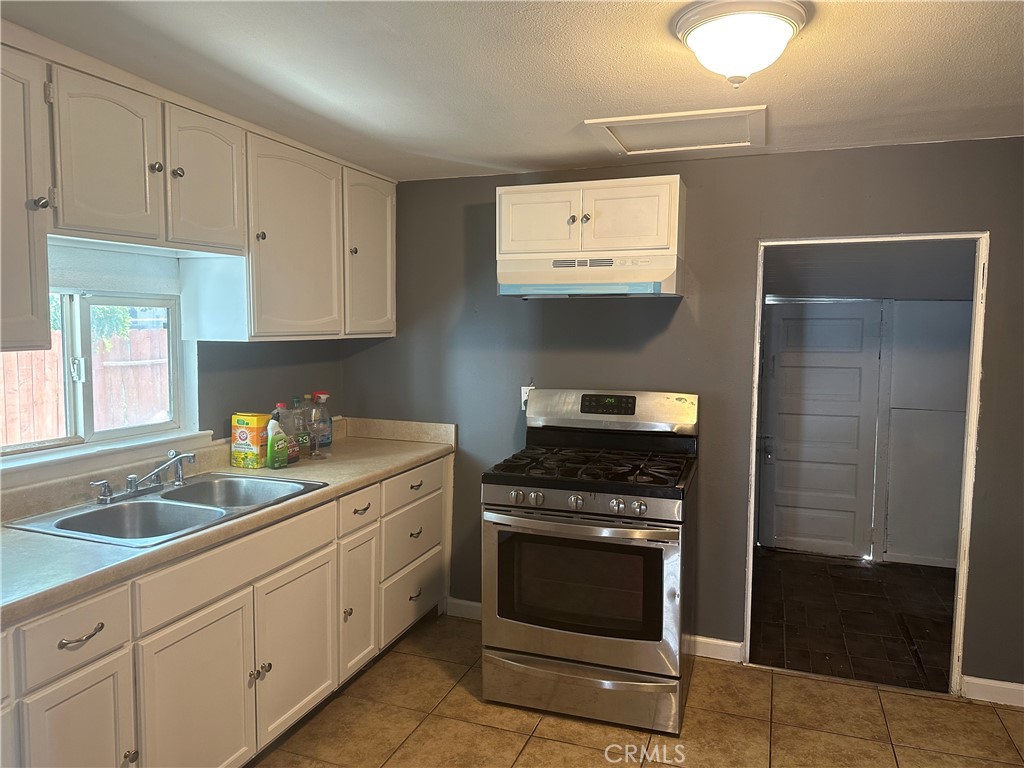 4 West 13th Street Merced, CA 95341 - Photo 13 of 23 a kitchen with white cabinets and appliances