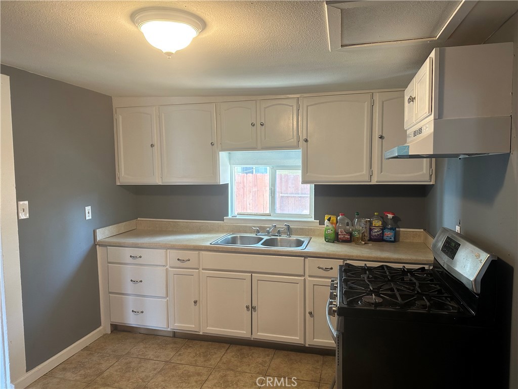 4 West 13th Street Merced, CA 95341 - Photo 14 of 23 a kitchen with a sink dishwasher stove and cabinets