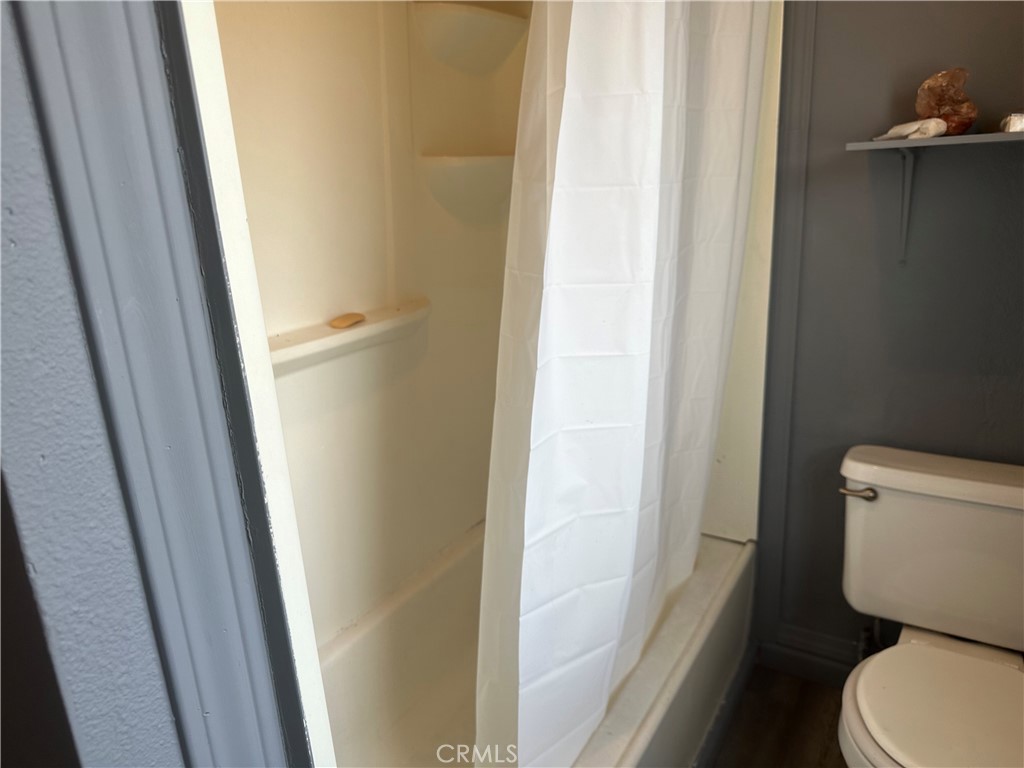 4 West 13th Street Merced, CA 95341 - Photo 17 of 23 a white toilet sitting next to a shower