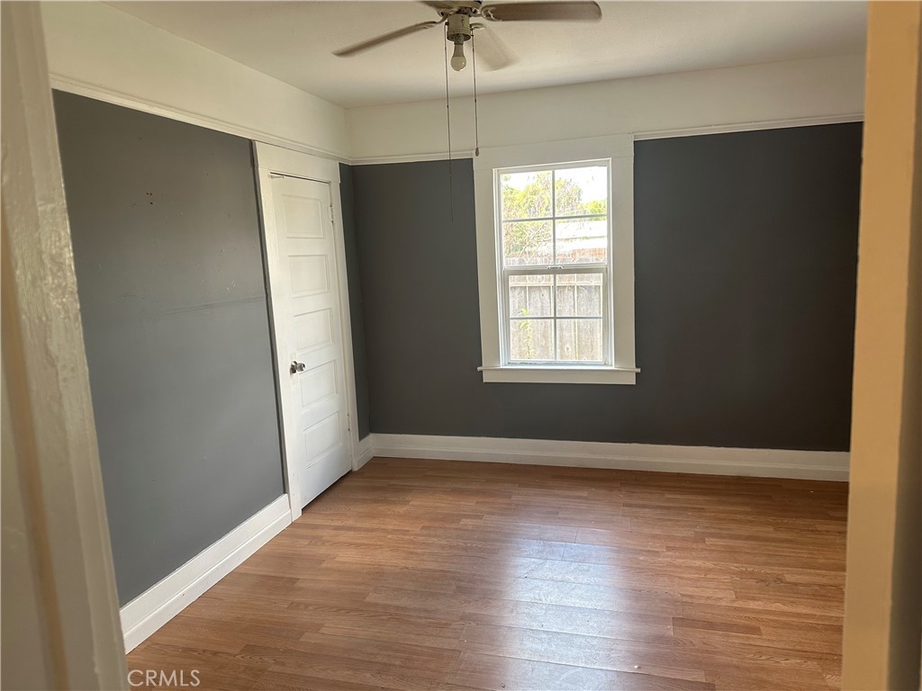 4 West 13th Street Merced, CA 95341 - Photo 9 of 23 an empty room with wooden floor and windows