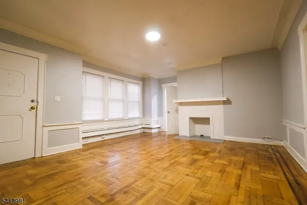 a view of an empty room with a fireplace and a window